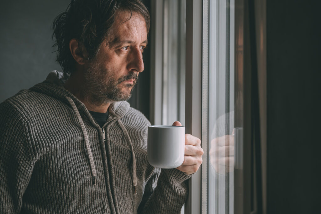 Thoughtful man holding a warm drink while taking time to reflect